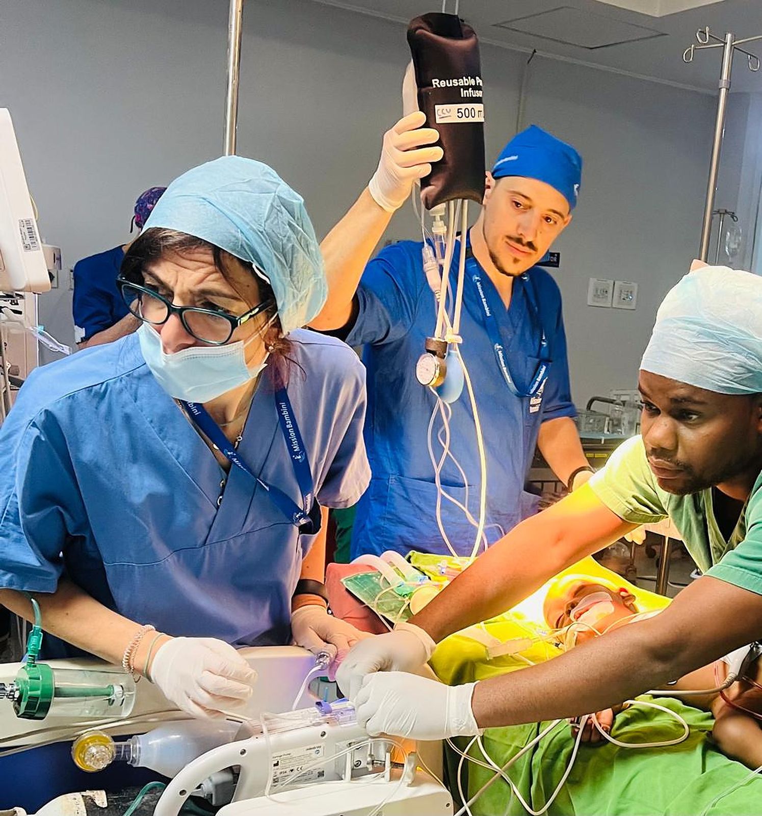 Clinicians learn together around a patient in an operating theatre